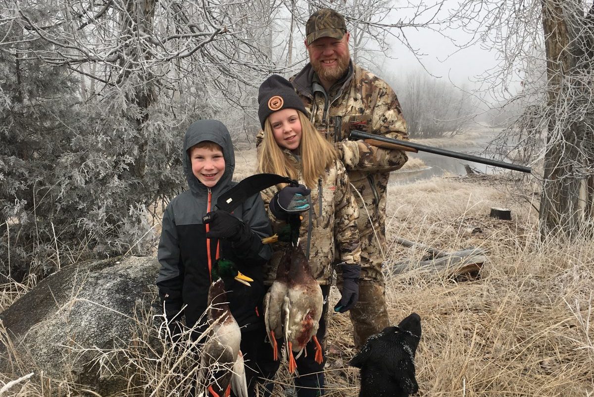 Land Tawney with his son and daughter posing with their waterfowl harvest