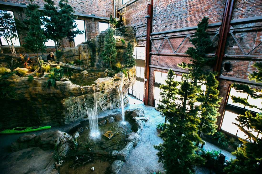 Waterfall and cliff face within the brick walled Michigan Outdoor Adventure Center.