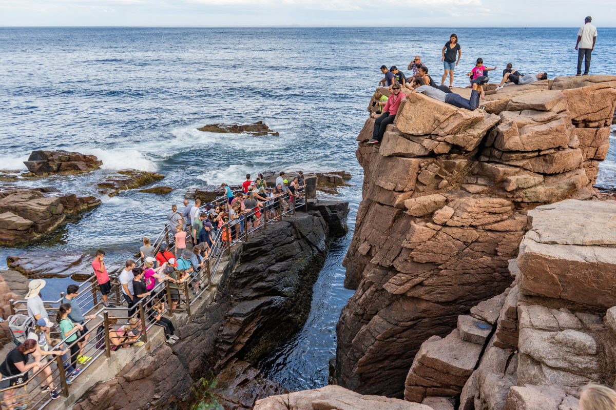 People crowd on the rocks at Acadia National Park